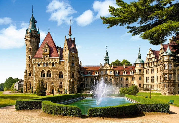 Moszna Castle in Poland with towers landscaped grounds and reflective water