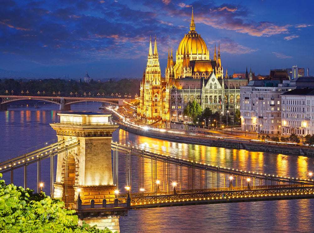 Hungarian Parliament Building illuminated at dusk beside the Danube River in Budapest