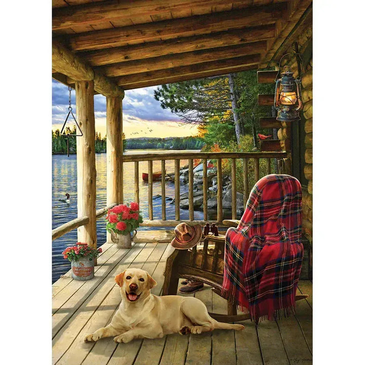 Jack Pine Cabin Porch 1000 Piece Jigsaw Puzzle featuring dogs relaxing on a rustic log cabin porch overlooking the wilderness - image