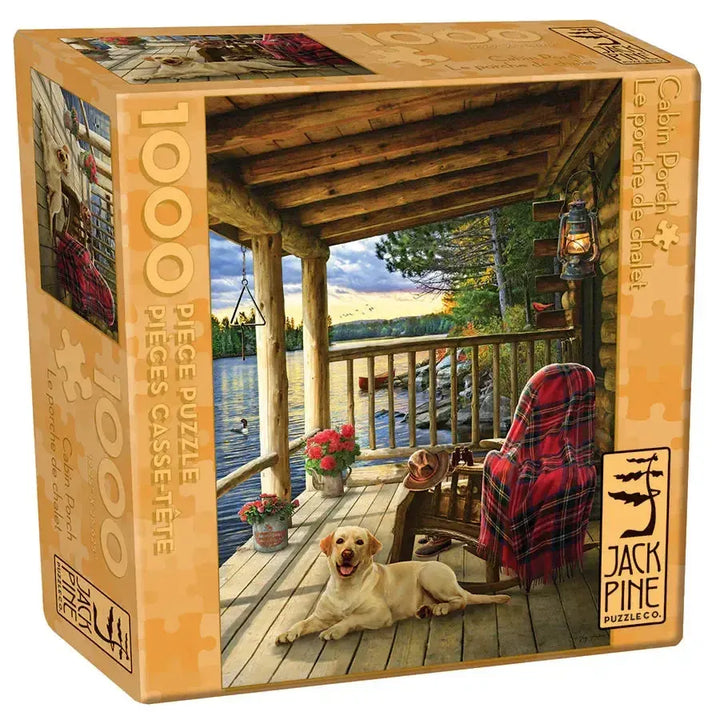 Jack Pine Cabin Porch 1000 Piece Jigsaw Puzzle featuring dogs relaxing on a rustic log cabin porch overlooking the wilderness
