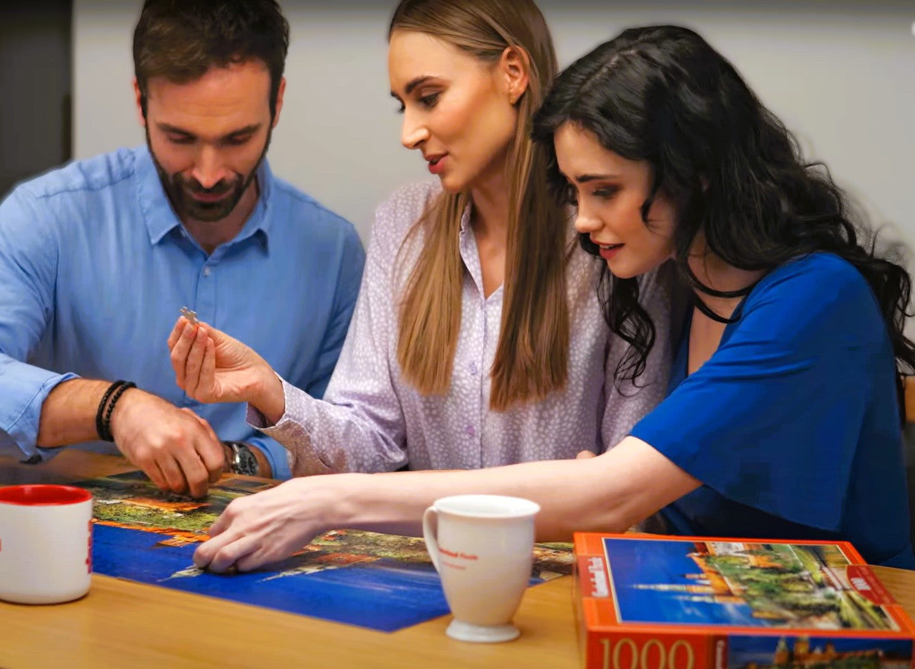 Adults assembling a large Castorland jigsaw puzzle together