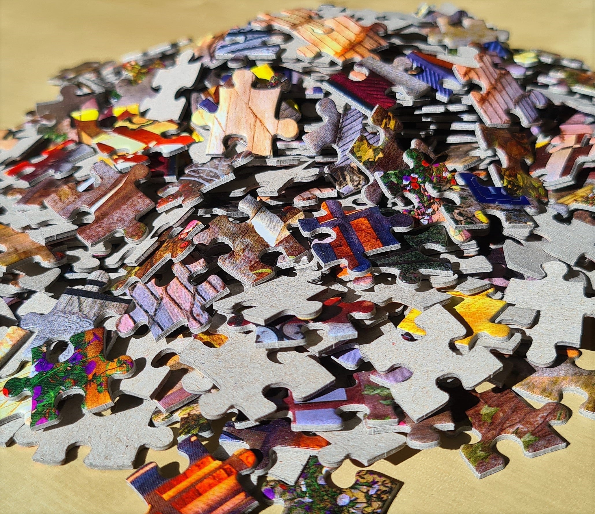 Assorted colorful jigsaw puzzle pieces spread across a puzzle-building surface