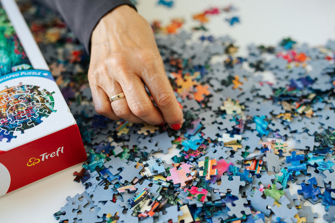 Hands assembling colorful jigsaw puzzle pieces