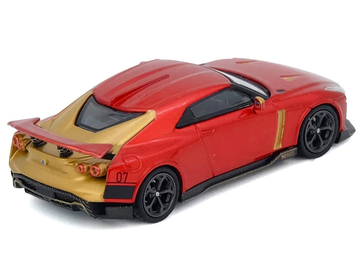 Nissan GT-R50 by ItalDesign 1:64 diecast model car by Inno Models in red metallic with gold accents displayed at an angle. 2