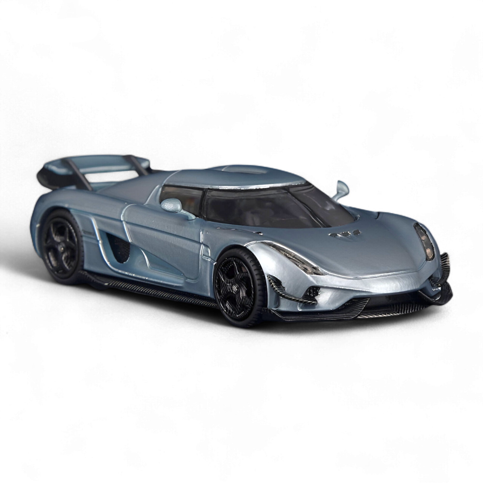 Side profile of the SC ART Koenigsegg Regera Glacier Blue 1:64 diecast model highlighting the sleek hypercar design, sculpted body lines, and premium collector detailing.