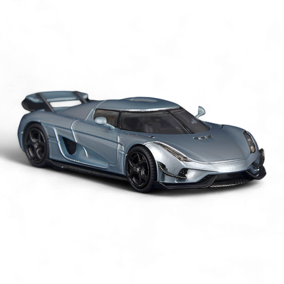 Side profile of the SC ART Koenigsegg Regera Glacier Blue 1:64 diecast model highlighting the sleek hypercar design, sculpted body lines, and premium collector detailing.
