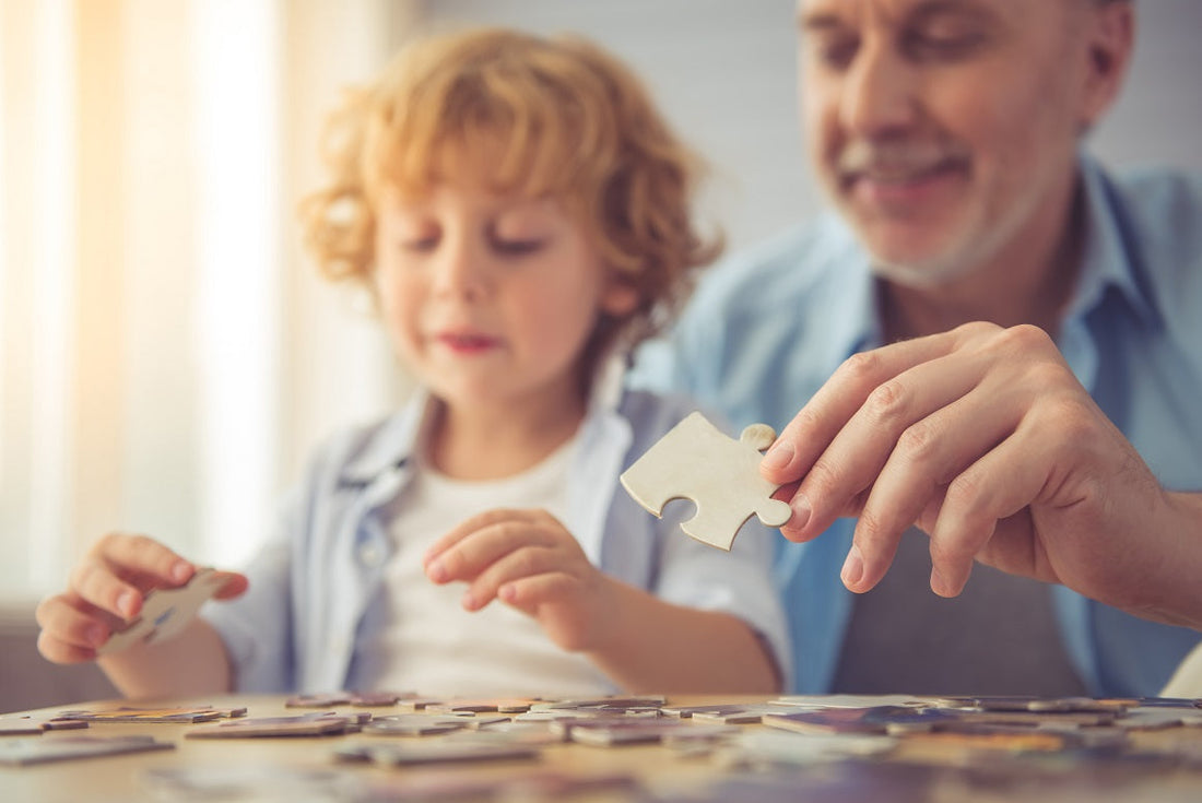 Child and adult working together on a jigsaw puzzle